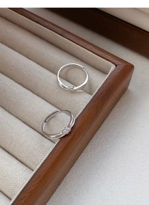 Dettaglio macro di anelli a nodo in argento sterling S999 in una scatola portagioie in legno