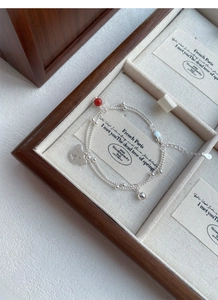 Close-up of S925 sterling silver bear bracelet with red agate bead in a jewelry box