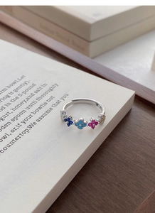 Detail of S925 silver ring with four-leaf clover colorful zircon on a vintage book