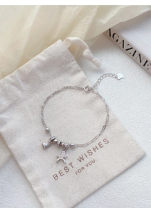 Détail des breloques poney et sac de monnaie en argent S925 sur un bracelet délicat