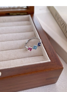Macro detail of S925 sterling silver ring featuring four multi-color clover accents