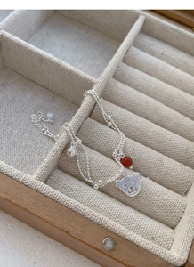 Detail view of double-layer S925 silver beaded bracelet with bear and red agate charm