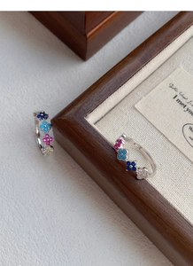 Macro view of S925 silver rings with colorful clover patterns and vibrant zircon inlays