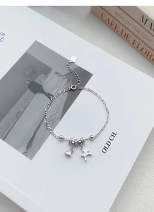 Gros plan d'un bracelet en argent S925 avec breloques porte-bonheur et pendentif cheval