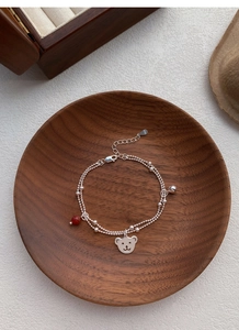 Detail of S925 sterling silver double-layer bracelet with bear charm and red agate bead