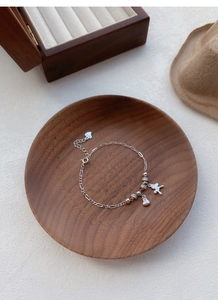 Détail macro du bracelet en argent S925 avec breloques lapin et sac d'argent porte-bonheur