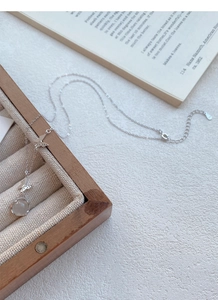 Détail du collier papillon en argent S925 avec calcédoine blanche sur boîte à bijoux