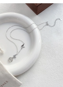 Détail du collier papillon en argent S999 avec calcédoine blanche et pochette à bijoux SHES