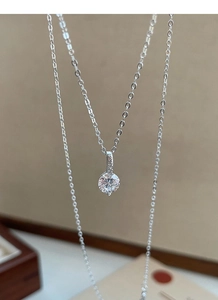 Gros plan du collier en argent S999 montrant le pendentif avec diamant scintillant
