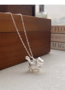 Macro shot of 999 silver cat pendant showing 3D matte texture and fine necklace craftsmanship