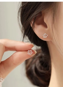 Gros plan de boucles d'oreilles fleurs évidées en argent S999 montrant les détails