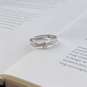 Anello con nodo in argento sterling S999 per coppie esposto su un libro d'epoca