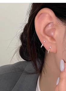 Nahaufnahme von minimalistischen S999 Silber-Ohrreifen und Solitär-Ohrsteckern am Model