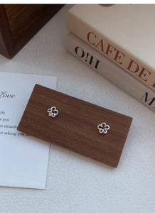 Détail macro de boucles d'oreilles fleur évidée en argent S999 sur bois vintage