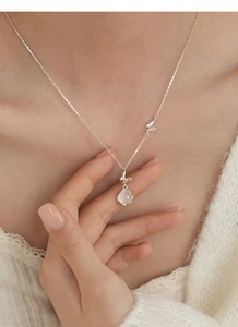 Détail du collier papillon en argent S999 avec calcédoine blanche porté par le mannequin