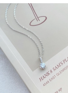 Gros plan d'un pendentif diamant rond étincelant sur une chaîne en argent S999