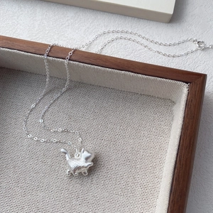 Minimalist S999 sterling silver necklace with cute matte cat pendant on wooden jewelry tray