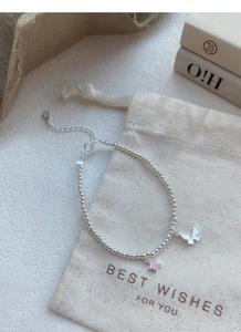 Détail de bracelet en argent sterling S925 avec breloques papillon et étoile rose
