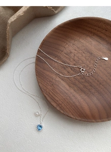 Detail der S925 Silberkette mit herzförmigem blauem Edelstein und kleinem Perlenanhänger