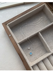 Detail der silbernen Herz-Halskette mit blauem Zirkon und Perle in einer Schmuckschatulle