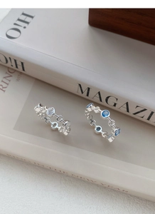 Detail of silver chain ring with alternating blue and white cubic zirconia stones