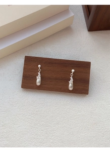 Macro detail of brushed S925 sterling silver teardrop earrings with zircon accents