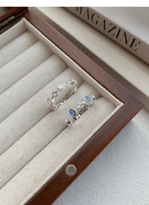 Detailed macro view of S925 sterling silver rings with zircon stones in a wooden box