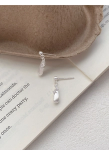 Detail of S925 sterling silver teardrop earrings with brushed texture and zircon stones