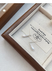 Macro detail of brushed S925 sterling silver teardrop earrings with zircon accents