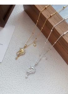 Détail de colliers licorne en argent et or avec zircons cubiques sur une boîte en bois