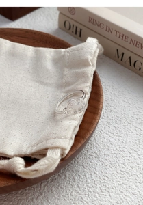 Detail view of S925 sterling silver rocking horse ring on a rustic linen pouch backdrop