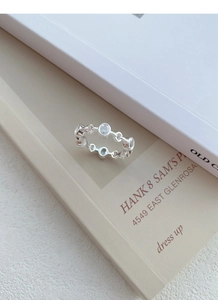 Detail of S925 silver chain ring featuring oval zircon stones on minimalist book cover