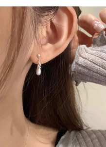 Close-up of S925 silver water drop earrings with a brushed matte texture on model