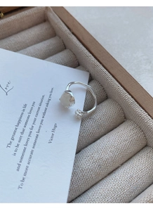Macro shot of S925 silver cat paw ring with white chalcedony on a jewelry gift box