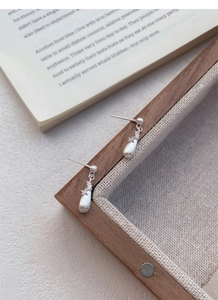 Detailed macro shot of S925 sterling silver teardrop earrings with a brushed matte finish