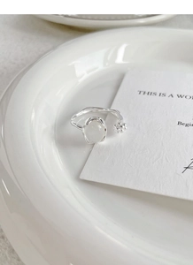 Detail view of S925 silver ring with white chalcedony bud and floral texture on ceramic tray