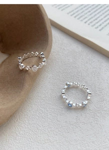 Detail of S925 sterling silver hollow rings with blue and clear zircon on a ceramic tray