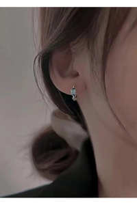Gros plan détaillé de la créole en argent S999 avec zircon bleu sur un mannequin