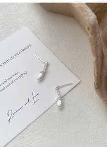 Macro detail of brushed S925 sterling silver drop earrings with tiny zircon accents
