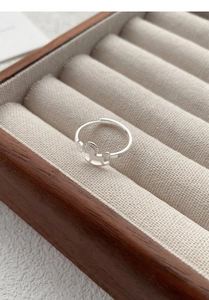 Close-up of a rocking horse silver ring displayed in a beige velvet jewelry box