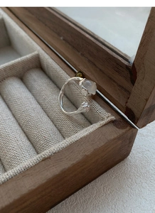 Detail of S925 silver ring featuring white chalcedony bud and floral textured band