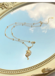 Détail du pendentif licorne doré avec zircons et étoile sur un miroir de rêve