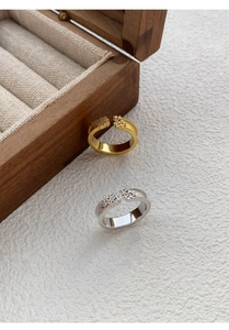 Macro detail of silver and gold starry rings with brushed texture and zircon stones