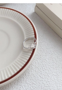 Detail view of S925 silver horse ring on ceramic plate with a minimalist design
