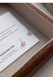 Macro shot of rectangular pink zircon stud earrings in S999 silver on a wooden tray