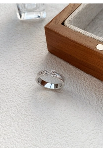 Close-up of S925 sterling silver ring with brushed texture, zircon inlay, and beaded edges