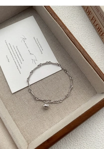 Detailed macro view of S999 sterling silver pumpkin pendant and twisted chain link bracelet