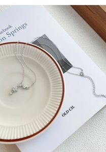 Macro detail of S999 sterling silver star pendant with cubic zirconia on a ceramic dish