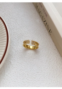 Close-up of golden vintage-style adjustable ring with white zircons and beaded texture