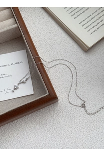 Close-up of S999 sterling silver star pendant necklace with zircons on a wooden tray